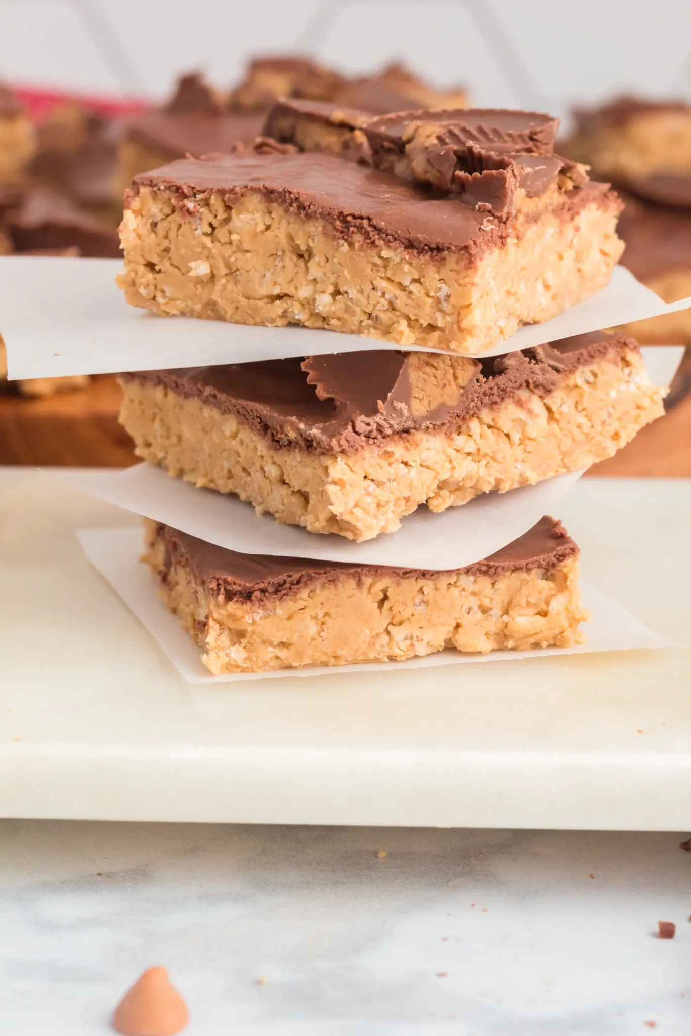 Stack of three crispy bars with the pan of dessert in the background.