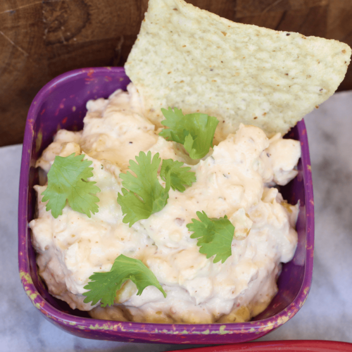 Crockpot Mexican Street Corn Dip in a purple bowl with chip